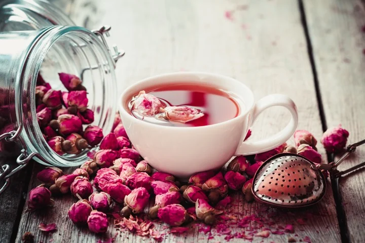 تصویری از یک چای رز با تعدادی قنچه گل رز