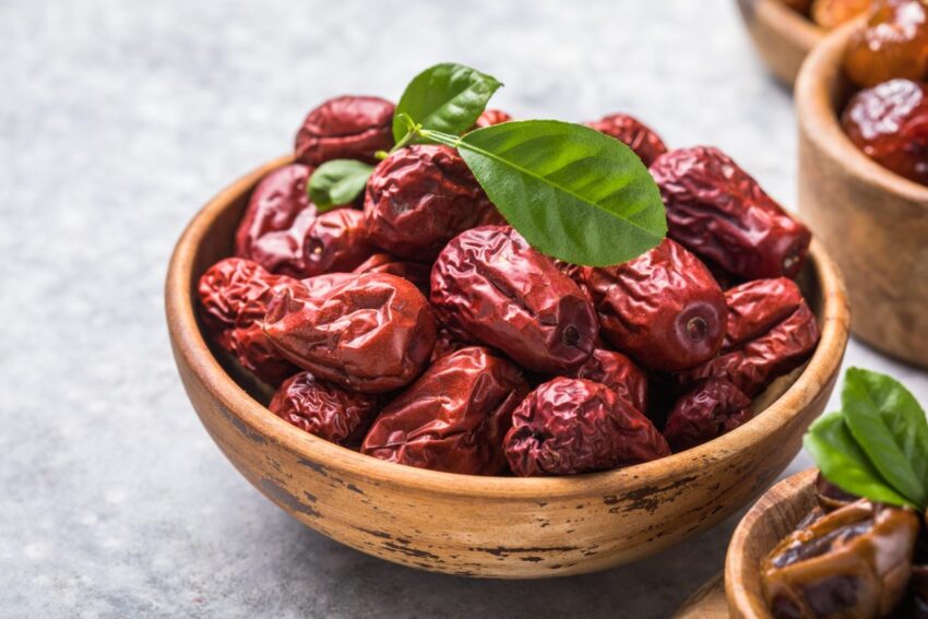 تصویری از تعدادی میوه عناب خشک شده در درون یک ظرف چوبی